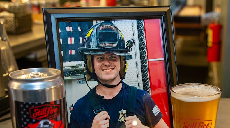 A photo of Chandler Patterson, who tragically died last summer, sat on the bar with the new Dude21 special brew in his honor. Family, friends & fellow firefighters gathered at Stillfire Brewing in Suwanee to honor Patterson with the launch on the new brew. His widow, Alyssa Patterson, reached out to the brewery, which was often she & the Gainesville firefighter's date night place, to see what they could do. She was able to help create the special brew with the brewmaster & friends. PHIL SKINNER FOR THE ATLANTA JOURNAL-CONSTITUTION.