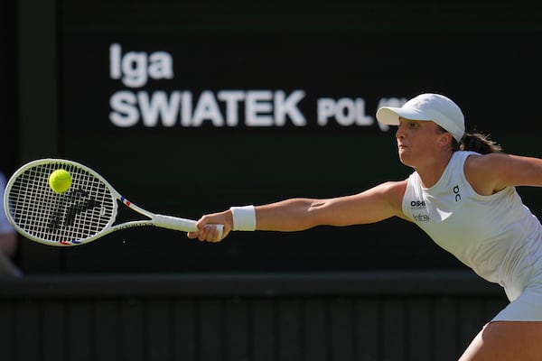 Poland's Iga Swiatek returns to Switzerland's Belinda Bencic during a women's singles semifinal match at the Wimbledon Tennis Championships in London, Thursday, July 10, 2025. (AP Photo/Kin Cheung)