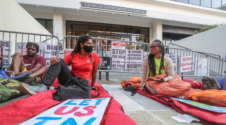About a dozen protesters spent a night in front of the Georgia Department of Labor building in downtown Atlanta last week, bitterly criticizing the decision to cut off federal pandemic benefits to about 167,000 jobless Georgians. Left to right - Chad Greenidge, Satya Vatti and Nicole Fears. The protest was organized by the New Georgia Project. (John Spink / John.Spink@ajc.com)