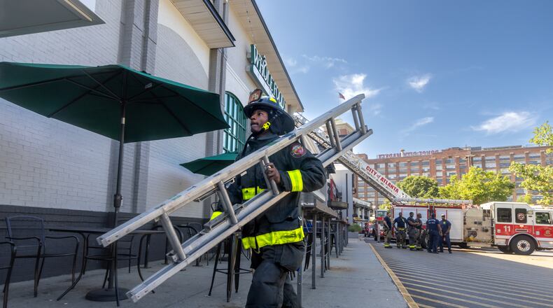 Atlanta firefighter J. Owens of 10-truck prepares to enter the Ponce De Leon Avenue Whole Foods after fire brok eout in a pizza oven. About 70 employees and 30 patronswere evacuated with no injuries. The fire had already been extinguished when fire crews arrived. (John Spink/AJC)