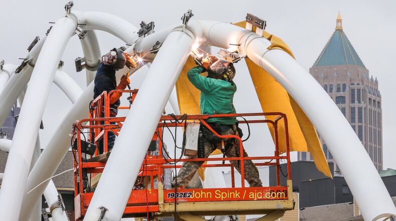 Two welders with Superior Rigging and Erecting, Justin Scheffield (left) and Tony Rovencio, put together the gateway arch elements Friday in phase 2 of the Peachtree Bridge Enhancement project amid pleasant conditions. JOHN SPINK / JSPINK@AJC.COM