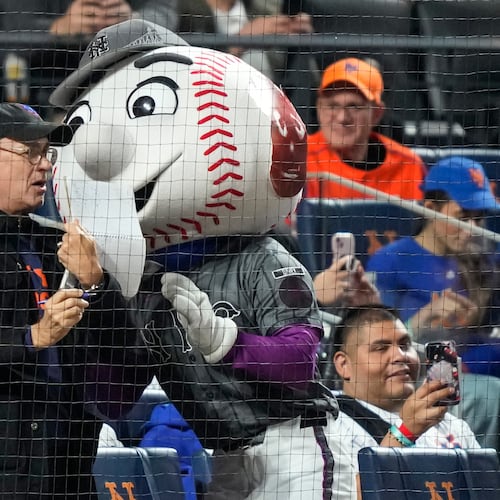 Actor/filmmaker Tom Hanks, center left, stands with Mr. Met, center right, during the sixth inning of a baseball game between the New York Mets and the New York Yankees, Saturday, May 16, 2026, in New York. (AP Photo/Yuki Iwamura)