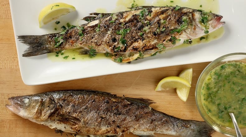 For the herb-grilled Mediterranean sea bass recipe, the fish are drizzled after grilling with a lemon, ginger and chive finishing sauce. (Michael Tercha/Chicago Tribune/TNS)