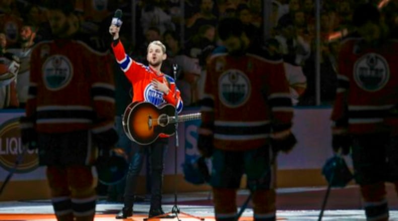 Canadian country singer Brett Kissel holds his faulty microphone up asking the crowd to help him sing the "Star-Spangled Banner" before the start of Game 3 of the NHL play-off series between the Anaheim Ducks and the Edmonton Oilers on Sunday, April 30, 2017 in Edmonton, Alberta.