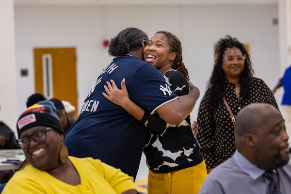 McDonough Mayor-elect Kam Varner (center right) is greeted by Scott Cozart at the Henry County Schools Welcome Center before a "Building a Better Blacksville" listening session on Thursday. Varner will be the city's first mayor who grew up in the historic Blacksville community. (Arvin Temkar/AJC)