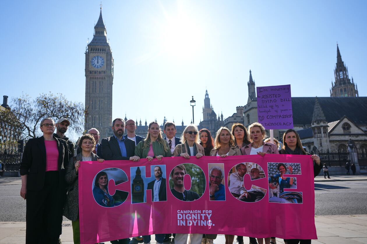 Campaigners hold a banner outside parliament in London as a proposed law to legalise assisted dying in England and Wales will run out of time on Friday, more than a year after MPs first voted in favour of it, Friday, April 24, 2026. (AP Photo/Kirsty Wigglesworth)