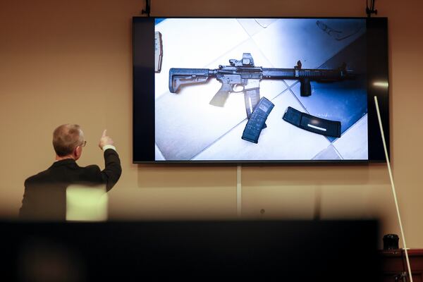 District Attorney Brad Smith, left, points to a weapon displayed on the screen during the first day of the trial of Colin Gray, the father of Apalachee High School shooting suspect Colt Gray. The scene was in a courtroom at the Barrow County courthouse, Monday, Feb. 16, 2026, in Winder, Ga. (Jason Getz/AJC)