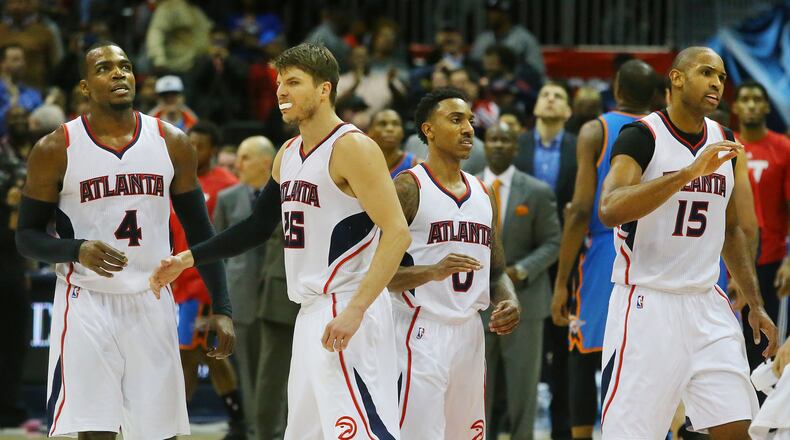 The Hawks’ Paul Millsap (from left), Kyle Korver, Jeff Teague and Al Horford give each other a hand as they take the lead during a game against the Oklahoma City Thunder.