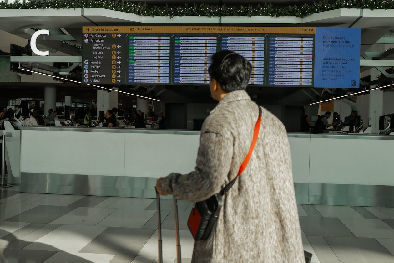 A traveler checks the flight schedule at LaGuardia International Airport on Saturday, Nov. 8, 2025, in New York. (AP Photo/Olga Fedorova)