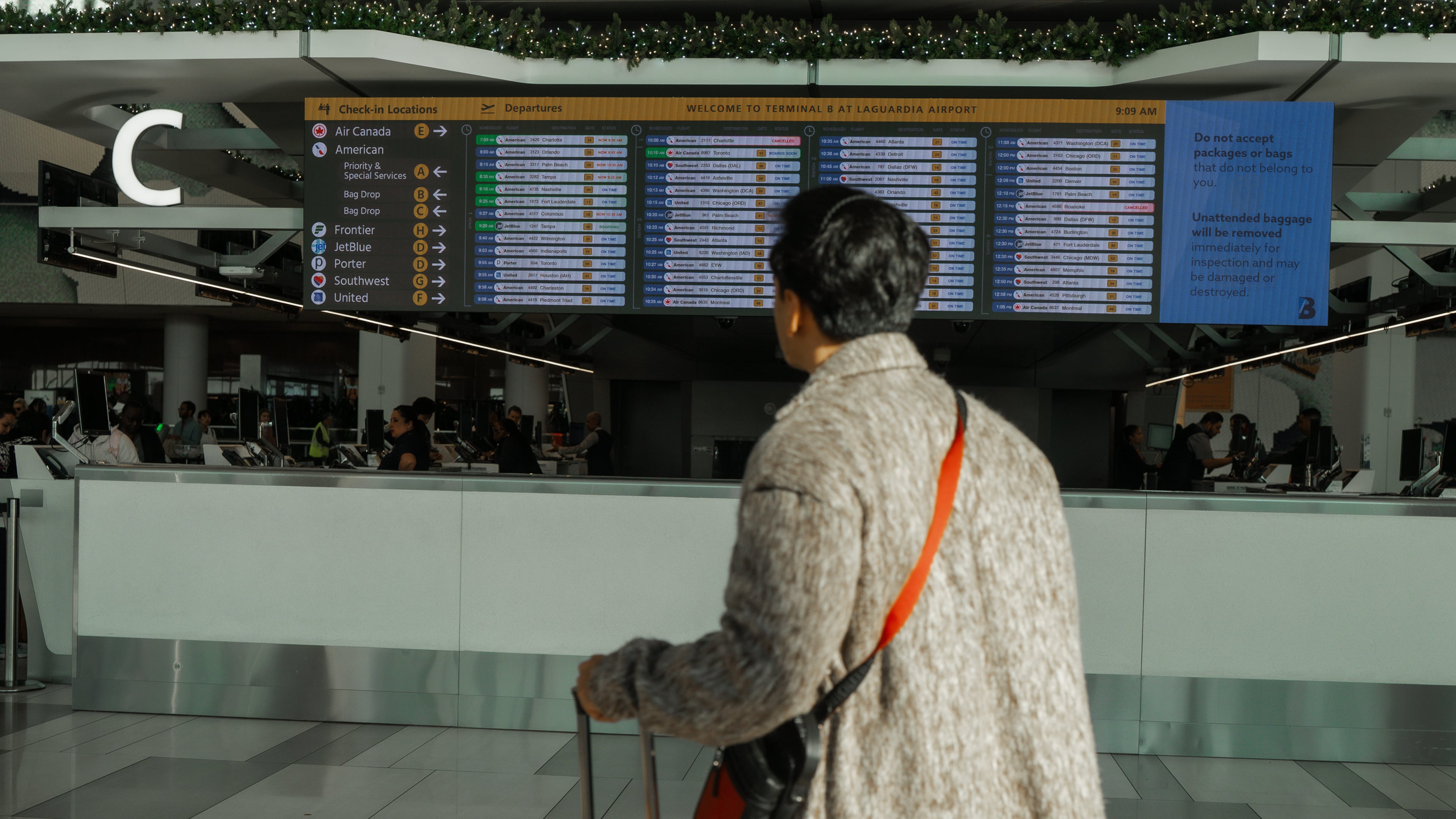 A traveler checks the flight schedule at LaGuardia International Airport on Saturday, Nov. 8, 2025, in New York. (AP Photo/Olga Fedorova)