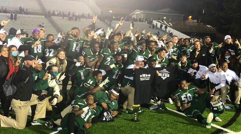 The Collins Hill players and staff pose with the Region 8 championship trophy.