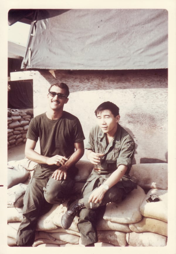 In this photo provided by William Fong, Fong is pictured sitting with a fellow soldier at a U.S. military base in Vietnam in 1969. (William Fong via AP)