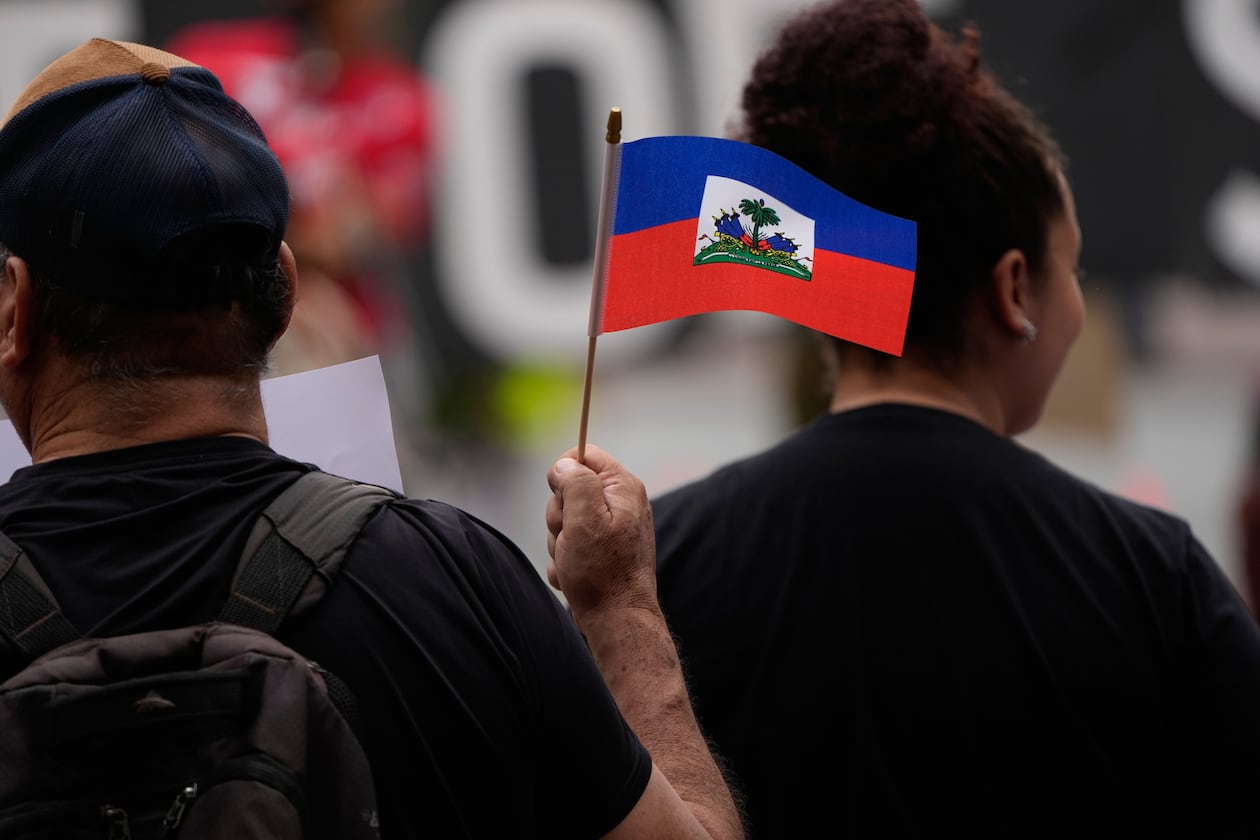 People hold Haitian flags and signs during a rally in support of immigrants living in the United States with temporary protected status on Thursday, July 9, 2026, in San Diego. (Gregory Bull/AP)