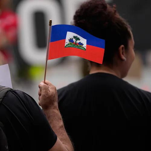 People hold Haitian flags and signs during a rally in support of immigrants living in the United States with temporary protected status on Thursday, July 9, 2026, in San Diego. (Gregory Bull/AP)