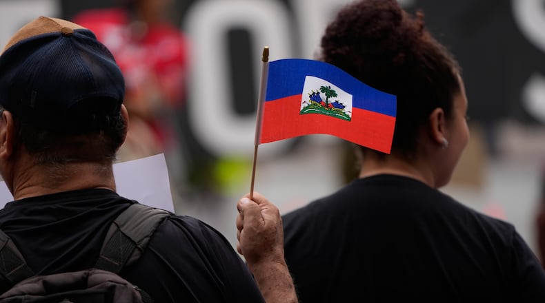 People hold Haitian flags and signs during a rally in support of immigrants living in the United States with temporary protected status on Thursday, July 9, 2026, in San Diego. (Gregory Bull/AP)
