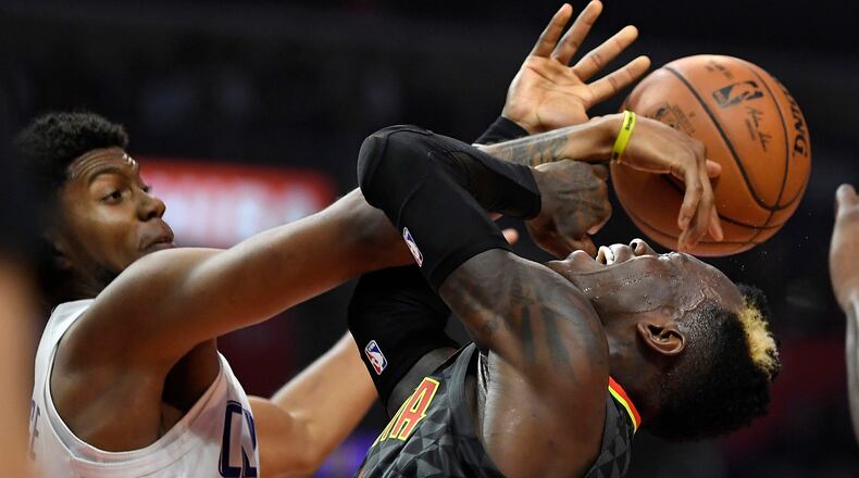 Atlanta Hawks guard Dennis Schroder, right, has his shot blocked by Los Angeles Clippers guard Tyrone Wallace during the first half of a basketball game, Monday, Jan. 8, 2018, in Los Angeles. (AP Photo/Mark J. Terrill)
