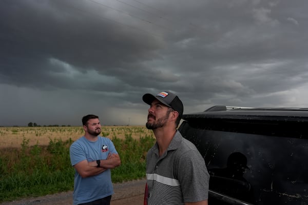 Victor Gensini, Northern Illinois University meteorology professor and a lead scientist of Project ICECHIP, right, and Logan Bundy, PhD Candidate at NIU and ICECHIP IOP assistant, look at cloud formations during a Project ICECHIP operation, Tuesday, June 3, 2025, south of Tipton, Okla. (AP Photo/Carolyn Kaster)