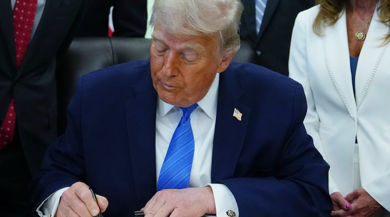 President Donald Trump signs a bill funding immigration enforcement in the Oval Office of the White House, Wednesday, June 10, 2026, in Washington. (AP Photo/Julia Demaree Nikhinson)