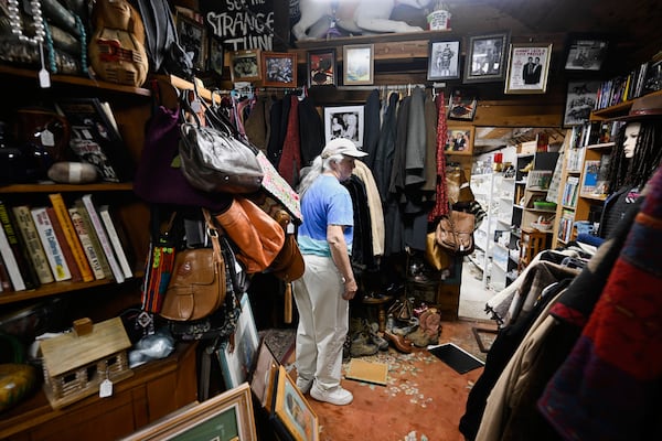 Tracy Turner, owner of the Wynola Junction, looks over pictures that fell from shelves when a earthquake hit Monday, April 14, 2025, in Julian, Calif. (AP Photo/Denis Poroy)