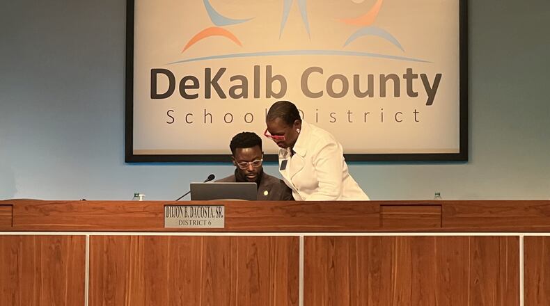 School board Chair Diijon DaCosta talks with board member Vickie Turner at a January 2022 meeting.