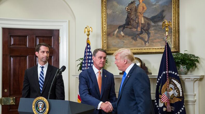 President Donald Trump shakes hands with Sen. David Perdue (R-Ga.) during an immigration announcement at the White House in August 2017. (Zach Gibson/Pool/Sipa USA/TNS)