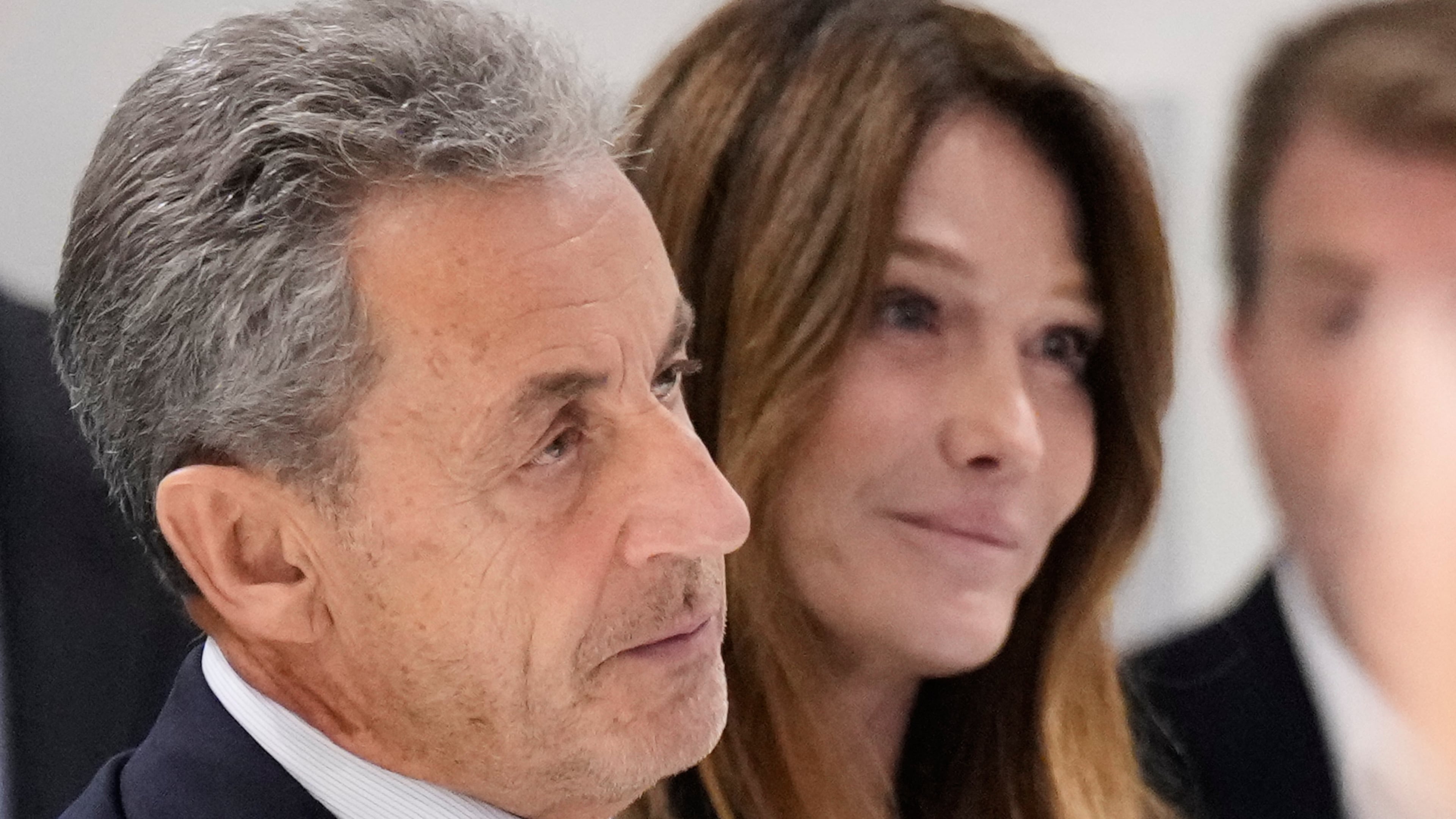 Former French President Nicolas Sarkozy, next to his wife Carla Bruni Sarkozy, speaks after a Paris court sentenced him to 5 years in prison and said he'll be incarcerated even if he appeals, after finding him guilty in his trial for alleged illegal campaign financing by Libya, Thursday, Sept. 25, 2025 in Paris. (AP Photo/Michel Euler)