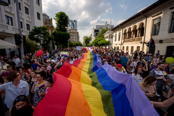 People hold a rainbow flag banner during the gay pride parade in Bucharest, Romania, Saturday, June 7, 2025. (AP Photo/Andreea Alexandru)