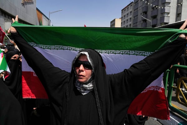 An Iranian worshipper carries her country's flag during a protest to condemn Israeli attacks on multiple cities across Iran, after the Friday prayers ceremony in Tehran, Iran, Friday, June 20, 2025. (AP Photo/Vahid Salemi)