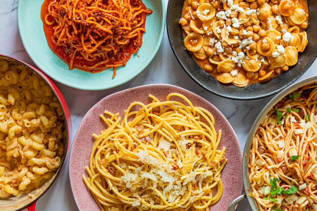 Get a tasty pasta dinner on the table using ingredients you already have at home. Clockwise from top left: Chili Crisp Assassin's Spaghetti, Tagine-Inspired Pasta e Ceci, Muffuletta Pasta, German-Inspired Carbonara and Miso-Kimchi Macaroni and Cheese. (Aaliyah Man for the AJC)