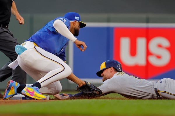 Minnesota Twins second baseman Willi Castro, front left, tags out Milwaukee Brewers' Brice Turang, right, on a stolen base-attempt in the sixth inning of a baseball game Friday, June 20, 2025, in Minneapolis. Initially called safe, a review of the play determined Turang was out. (AP Photo/Bruce Kluckhohn)