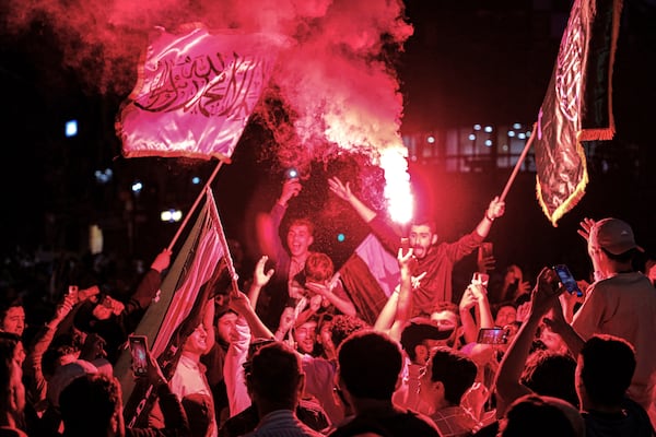 Syrians wave Saudi and Syrian flags in celebration after U.S. President Donald Trump announced plans during his visit to Saudi Arabia to ease sanctions on Syria and normalize relations with its new government, in Homs, Syria, late Tuesday, May 13, 2025.(AP Photo/Omar Albam)