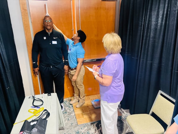 Wellstar medical staff Myles Abdul-Mateen and Cindy Ellis-Bailey take former Atlanta Falcons player and NFL retiree Philip McKinnely's measurements at a health screening. (Courtesy of Wellstar Health System)