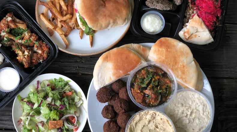 A feast from Cafe Raik in Duluth features (clockwise from top): shawafel sandwich with hand-cut fries; beef kababs with mejadara; appetizer assortment, fattoush salad; and fried cauliflower. Wendell Brock for The Atlanta Journal-Constitution