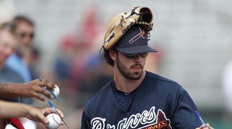 Dansby Swanson signs autographs before a spring training road game in Jupiter, Fla. The only rookie on the Braves’ opening-day roster is already one of the team’s most recognizable and popular players in recent years. (AP Photo)