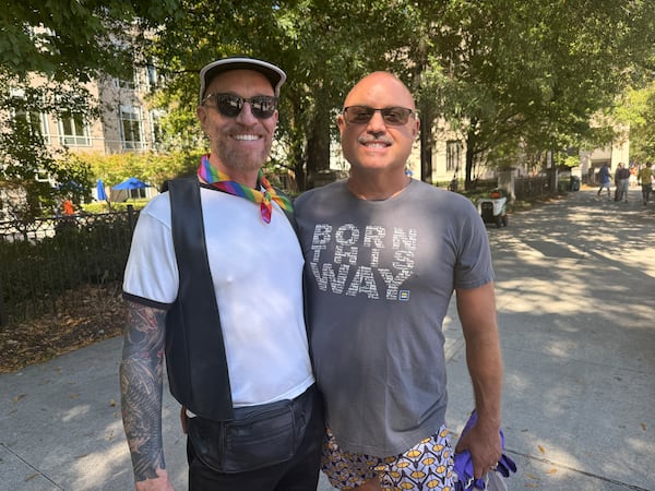 Sean Kelly (left) and his husband, JT Jemison, were visiting Atlanta from Wilton Manors, Florida. Kelly's employer, Cox, had a float in the parade. (Danielle Charbonneau/AJC) 