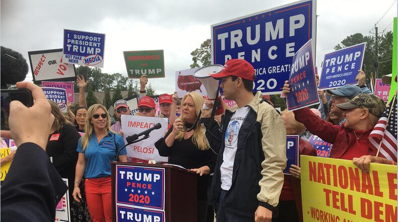 Julianne Thompson addresses a crowd of President Donald Trump supporters protesting outside Rep. Lucy McBath's Sandy Springs office.