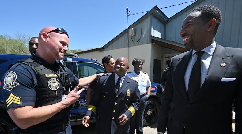 Atlanta Police Chief Rodney Bryant (center) smiles as he talks with Sgt. Ryan Heald (left) and Mayor Andre Dickens (right) after announcing the chief’s retirement at the Atlanta Police Department Zone 4 headquarters on Friday, April 15, 2022. (Hyosub Shin / Hyosub.Shin@ajc.com)