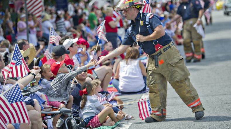 Cobb County Fire Lt. Ryan Gillen (right) gives Field Richardson a high-five as he marches through Historic Marietta Square during the city’s Freedom Parade last year. This year’s Freedom Parade begins at 10 a.m. July 4. JONATHAN PHILLIPS / SPECIAL