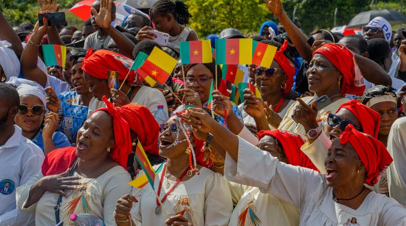 People cheer as Pope Leo XIV arrives in Yaounde, Cameroon, Wednesday, April 15, 2026. (AP Photo/Welba Yamo Pascal)