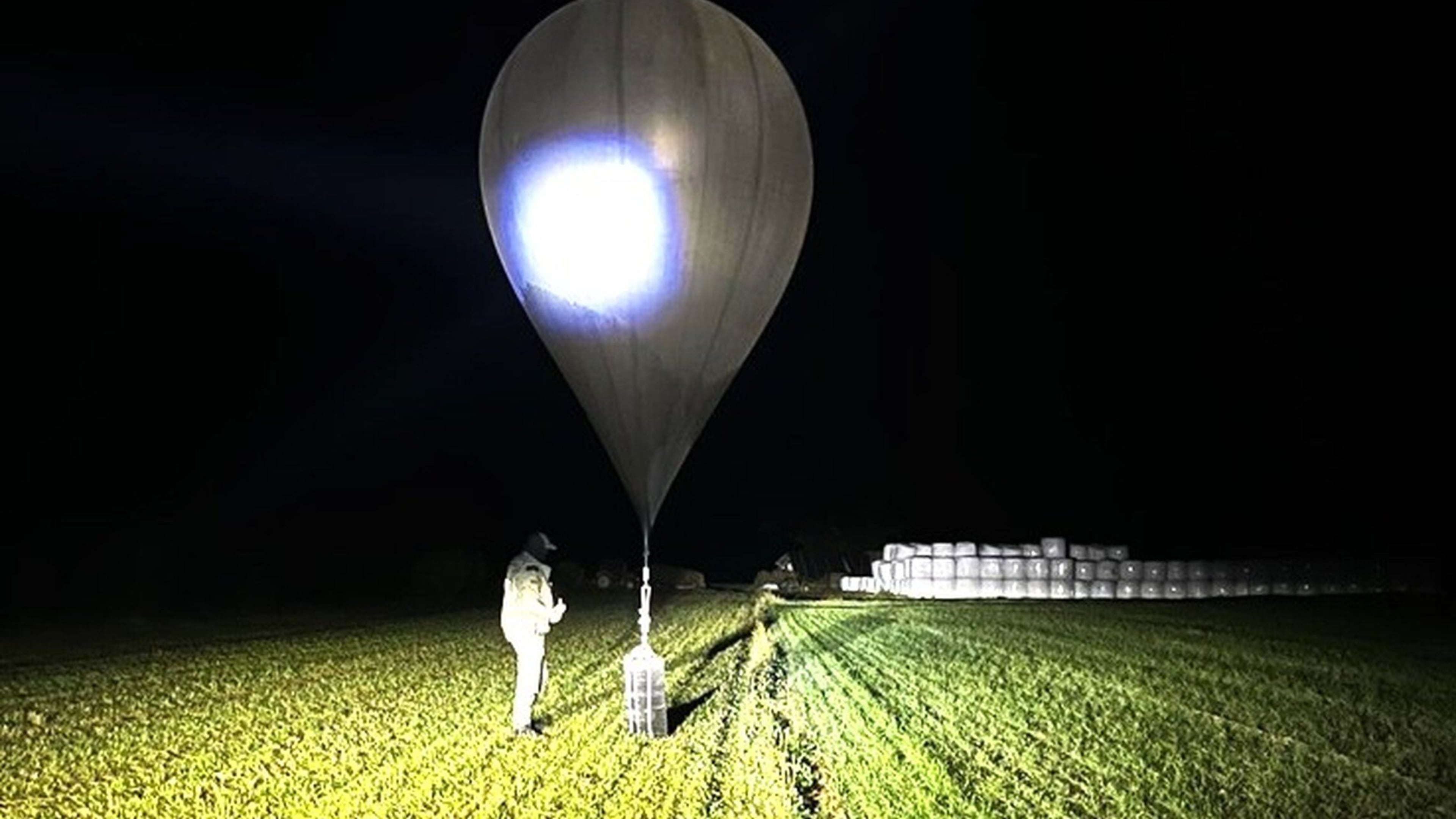 FILE - In this undated photo released by the State Border Guard Service, an officer inspects a balloon used to carry cigarettes into Lithuania, because Belarussian smugglers often use them to ferry the contraband into the European Union (State Border Guard Service via AP, File)