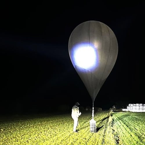 FILE - In this undated photo released by the State Border Guard Service, an officer inspects a balloon used to carry cigarettes into Lithuania, because Belarussian smugglers often use them to ferry the contraband into the European Union (State Border Guard Service via AP, File)