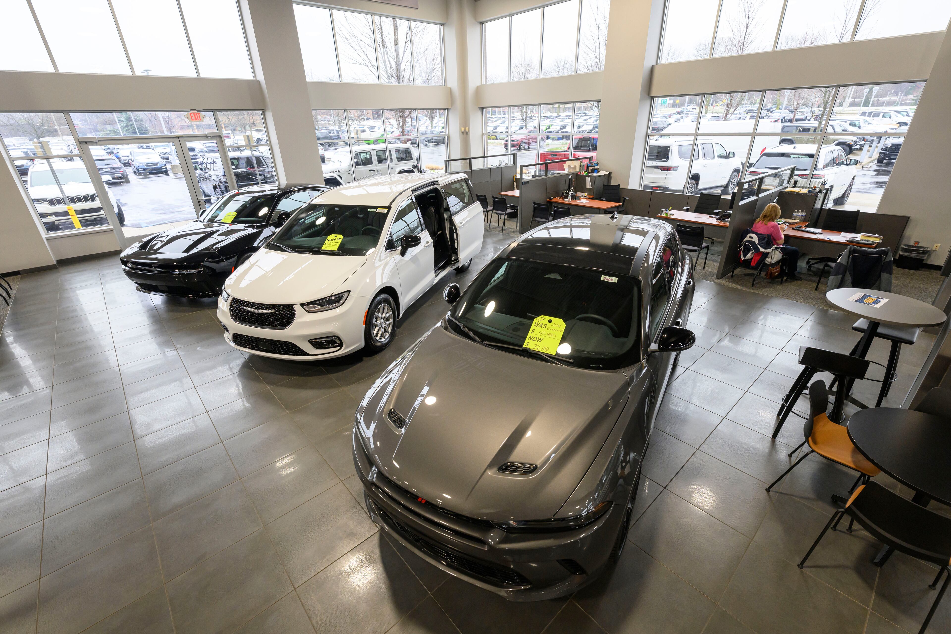 Cars sit in the showroom at the Golling Chrysler Dodge Jeep Ram dealership in Bloomfield Hills, Mich. Dealerships can offer premium customizations or added services as a way to charge consumers more. (David Guralnick/The Detroit News/TNS)