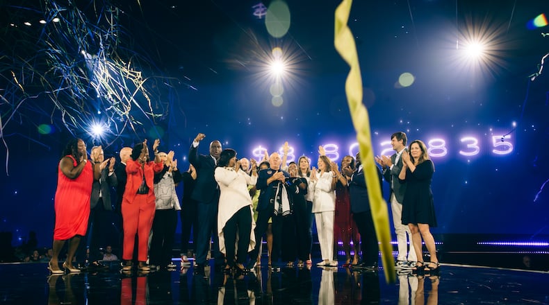 The Same House supporters celebrate as they announce that the 2023 Beloved Benefit raised $8.8 million for charity. (Olivia Bowdoin for the AJC).