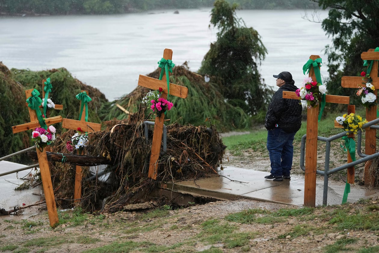 FILE - Rain falls as Irene Valdez visits a make-shift memorial for flood victims along the Guadalupe River, Sunday, July 13, 2025, in Kerrville, Texas. (AP Photo/Eric Gay, File)