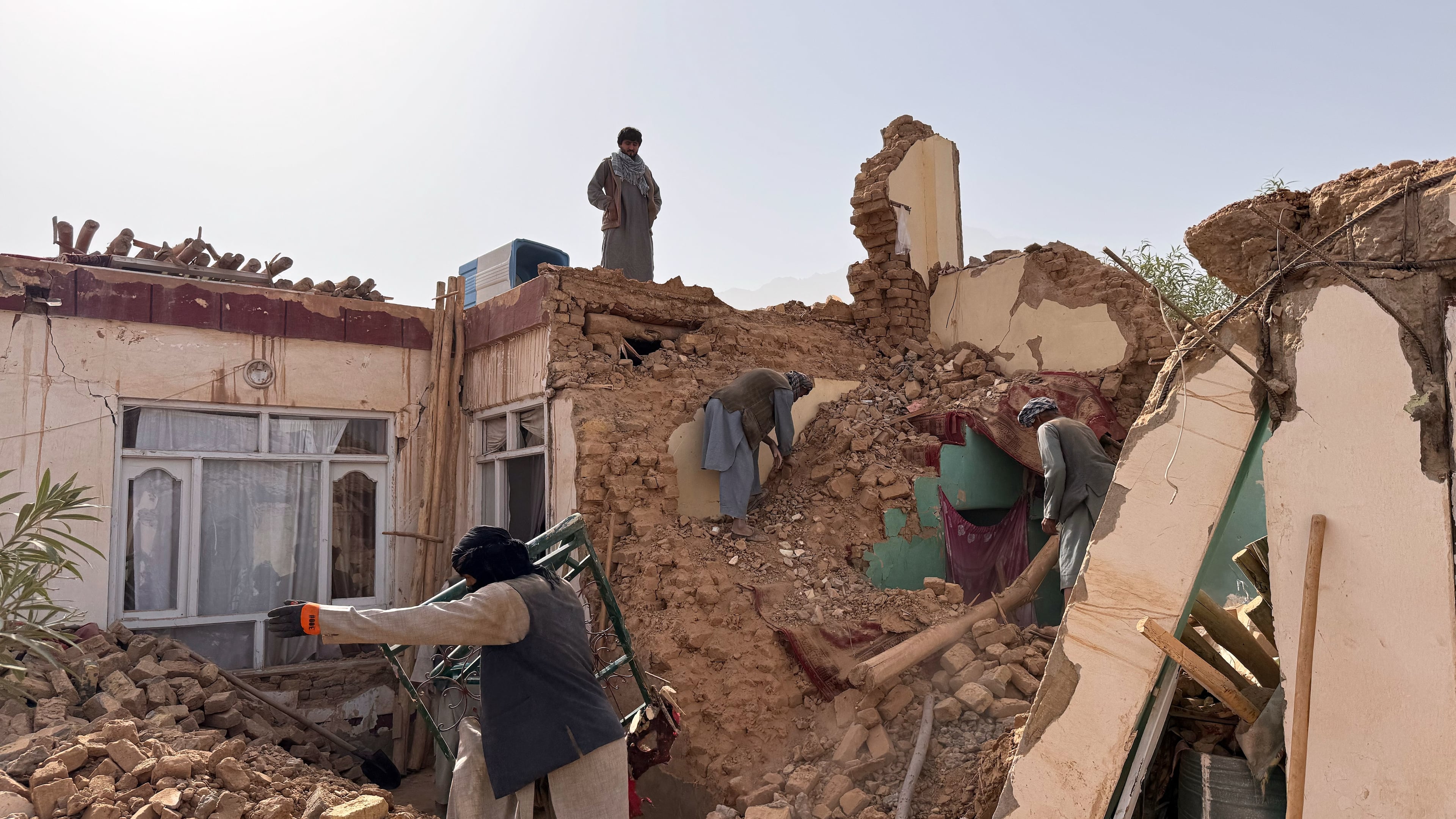 Locals search among the rubble of a destroyed house after a 6.3 powerful in a rural area of the Khulm District, Samangan Province, northern Afghanistan, Monday, Nov. 3, 2025.(AP Photo/Sirat Noori)