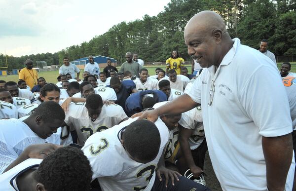 Southwest DeKalb football coach Buck Godfrey (right) talks with his players during a practice in 2009. (Hyosub Shin/AJC)