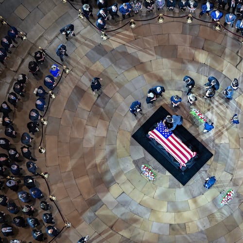 People pause at the casket of Sen. Lindsey Graham, R-S.C., in the Rotunda of the U.S. Capitol at a congressional tribute Tuesday, July 28, 2026, in Washington.(Kenny Holston/The New York Times via AP, Pool)