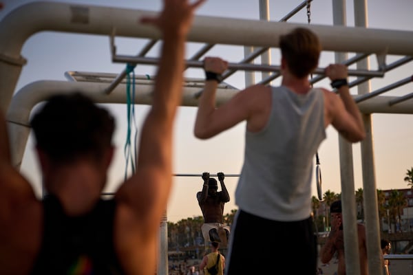 People work out in an open-air gym next to the beach in Barcelona, Spain, Tuesday, June 25, 2025. (AP Photo/Emilio Morenatti)