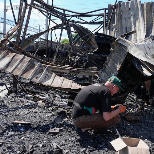 An owner rummages through the ashes on the site of the ruined city marketplace after Russian recent missile attack in Kyiv, Ukraine, Wednesday, June 24, 2026.(AP Photo/Efrem Lukatsky)