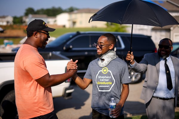 Malachi Chaney, 19, right, meets neighbor Curtis Bryant for the first time as the Chaneys visited the remains of their home after it was destroyed by an EF-2 tornado, Wednesday, June 25, 2025, in Locust Grove, Ga. (Jason Getz/AJC)